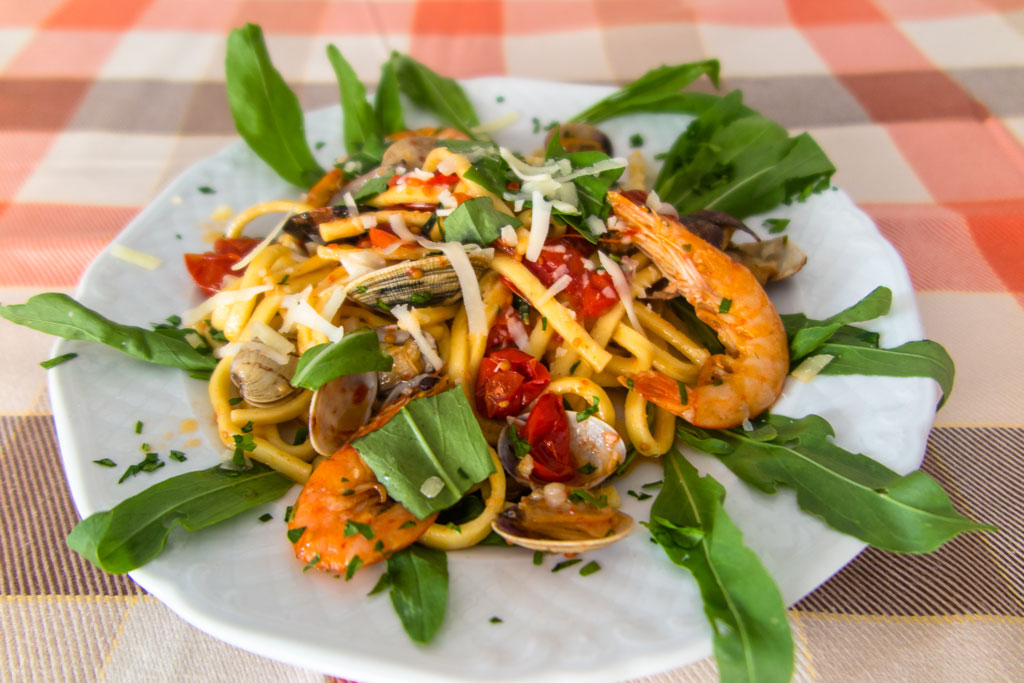 Scialatielli con gamberetti e vongole su letto di rucola e scaglie di parmigiano